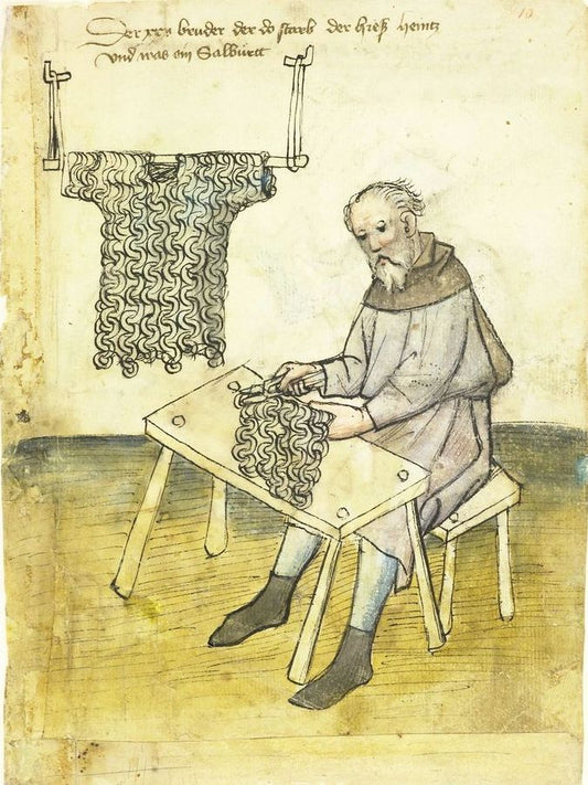 A medieval illustration of a balding, bearded man sitting at a table, riveting chainmail rings using a  pair of tongs. A completed chainmail shirt hangs from a rod in the background. Hausbuch der Mendelschen Zwölfbrüderstiftung, Band 1. Nürnberg 1426–1549